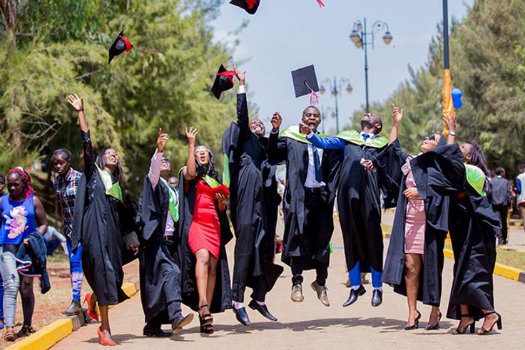 Graduates throwing their hats in the air to celebrate