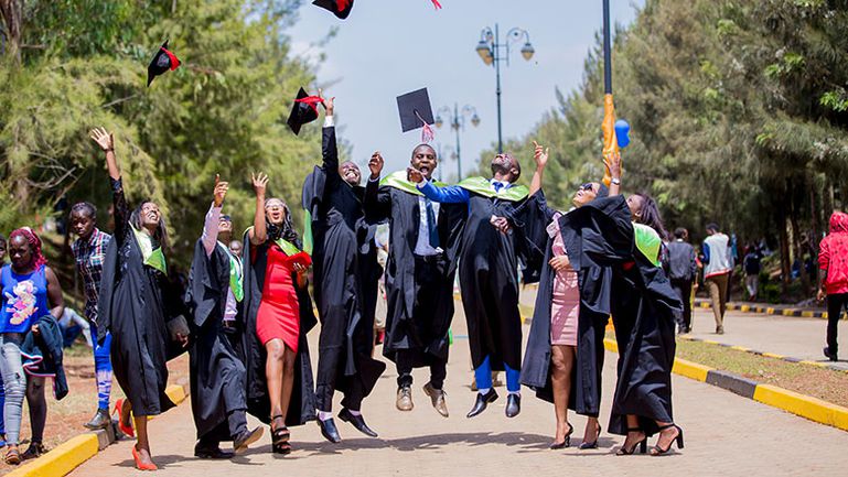 Graduates throwing their hats in the air to celebrate
