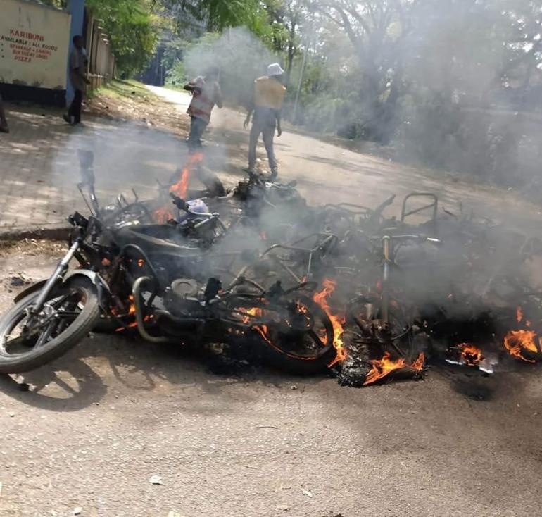 A Boda Boda motorcycle burns to ashes on the street after violent clashes in Kisumu City on Sunday (Image: Files)