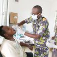 A Kenya Defence Forces specialist officer (middle) offers dental services to a civilian