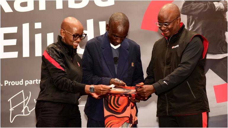 Eliud Kipchoge signs a commemorative shirt alongside Absa Bank Kenya Marketing & Corporate Affairs Director Mwihaki Wachira and Personal & Private Banking Director Moses Muthui during the unveiling of a landmark partnership.