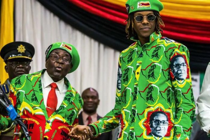 Former Zimbabwean President Robert Mugabe shakes hands with his son, Robert Mugabe Jr., who pleaded guilty to drug possession on November 13, 2025