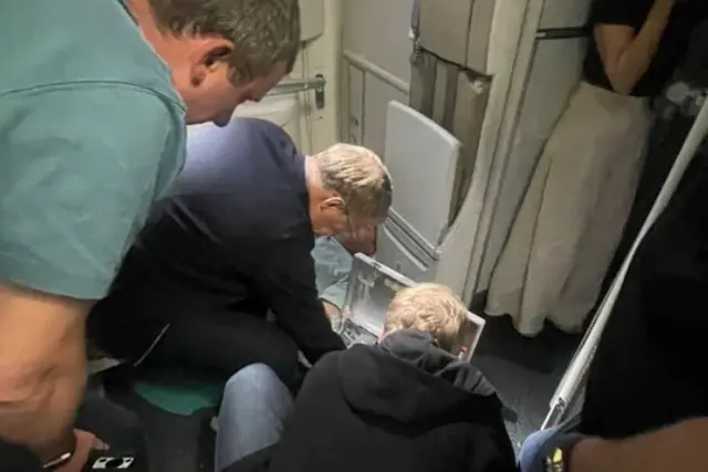 Russian Health Minister Mikhail Murashko attending to a passenger's emergency