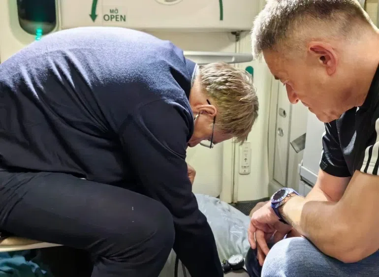 Russian Health Minister Mikhail Murashko attending to a passenger's emergency