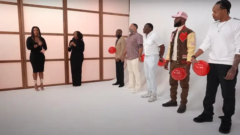 A panel of single men or women stand in a line, each holding an inflated balloon (Image: Files)