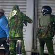 Police officers confront city hawker in Nairobi during protests