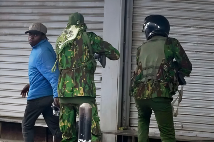 Police officers confront city hawker in Nairobi during protests
