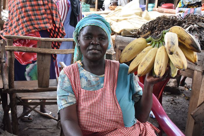 Jennifer Nagut from Maero village in Uganda displays the bananas at her stall in Busia, Kenya. She is among several Ugandan women who cross the border every day to sell nutritious foodstuffs to Kenya | Photo by Faith Matete