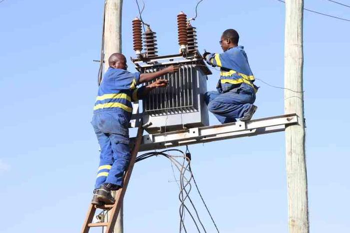 Kenya Power staff fixing a transformer