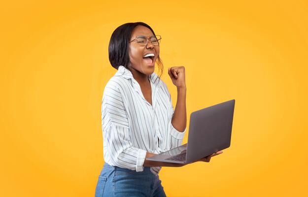A person showing excitement while holding a laptop