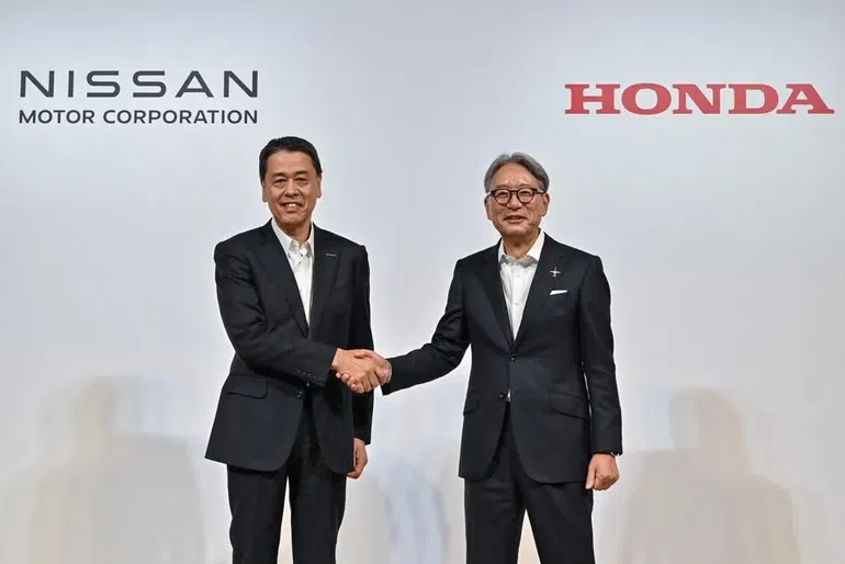 Makoto Uchida (L), Nissan CEO shakes hands with Toshihiro Mibe (R), President of Honda