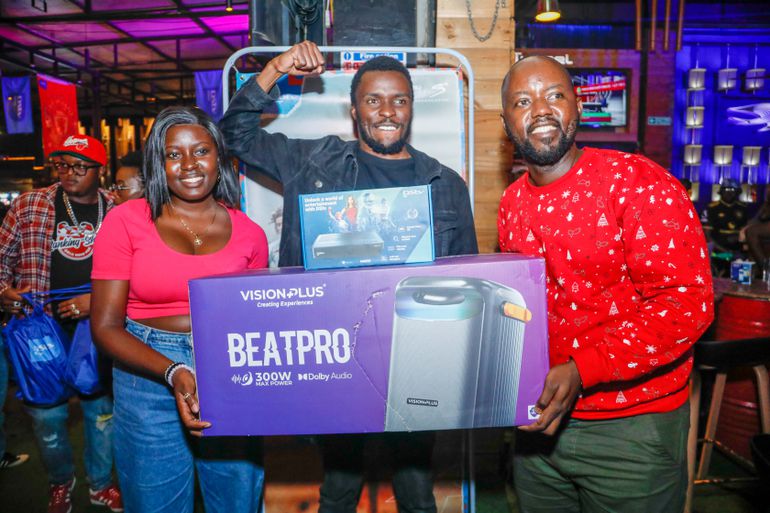 Kerina Bright Vision Plus Marketing Assistant (Left) and Elisha Kamau (Right) Public Relations Manager at MultiChoice Kenya presents Michael Likeya with a Vision Plus Bluetooth speaker