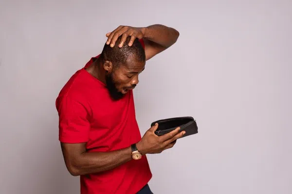 A man looking at his empty wallet