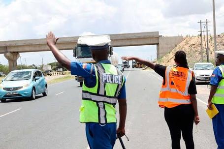 Traffic police officers wave down traffic at a road block on Thika Road (Image: Files)