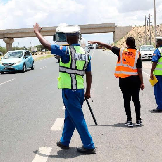 Traffic police officers wave down traffic at a road block on Thika Road (Image: Files)