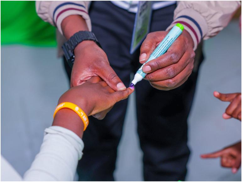 An IEBC official marks the finger of a voter. (Photo: IEBC)