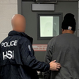 Homeland Security Investigations (HSI) agent arresting a suspect on charges of alleged false statements related to voter registration and visa fraud