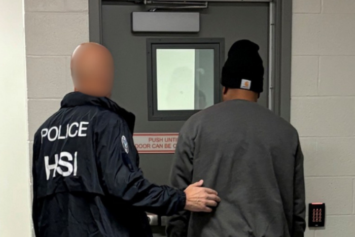 Homeland Security Investigations (HSI) agent arresting a suspect on charges of alleged false statements related to voter registration and visa fraud