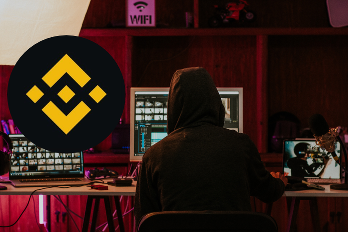 Man wearing hoodie and using computers and an inset of Binance logo