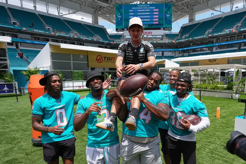 Kimi Antonelli, piloto de Mercedes, y jugadores de los Miami Dolphins | AP