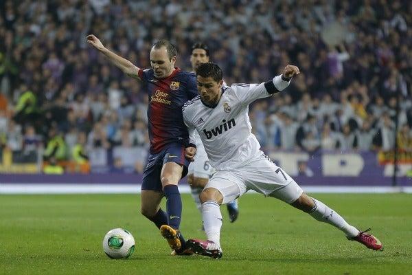 Iniesta y Ronaldo buscando el balón | AP