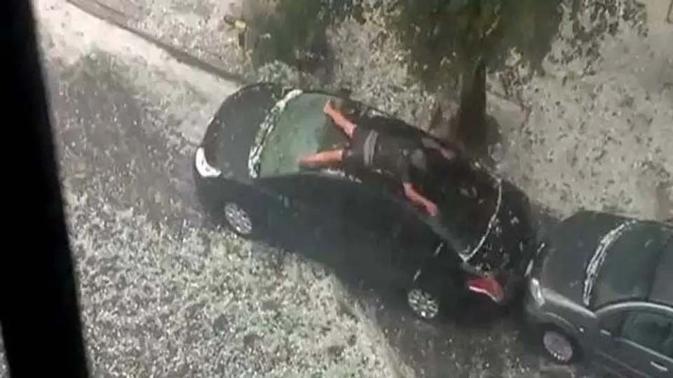 Hombre nada sobre su auto en pleno granizo