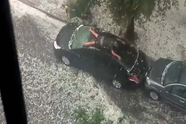 Hombre nada sobre su auto en pleno granizo