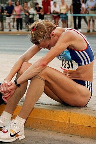 Paula Radcliffe se sienta en la acera después de abandonar el maratón olímpico en 2004 | ESPECIAL