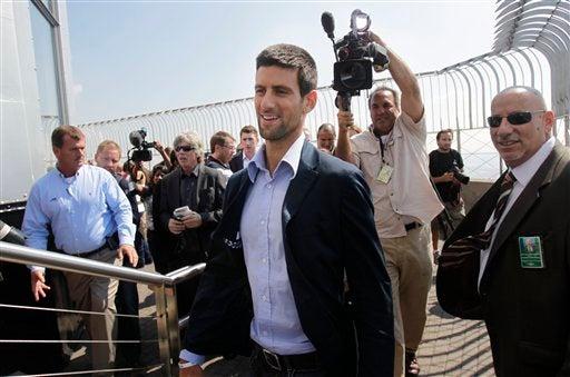 Djokovic disfruta la vista desde el  Empire State al lado de su trofeo. FOTO: AP