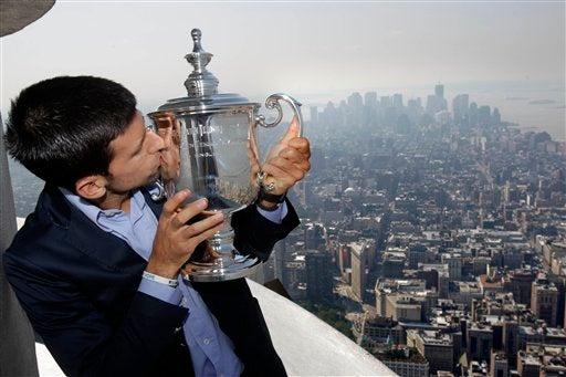 Djokovic disfruta la vista desde el  Empire State al lado de su trofeo. FOTO: AP