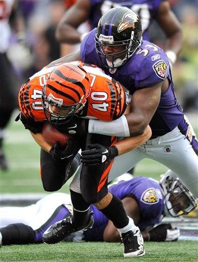 Brian Leonard es tacleado por Jameel McClain. FOTO: AP