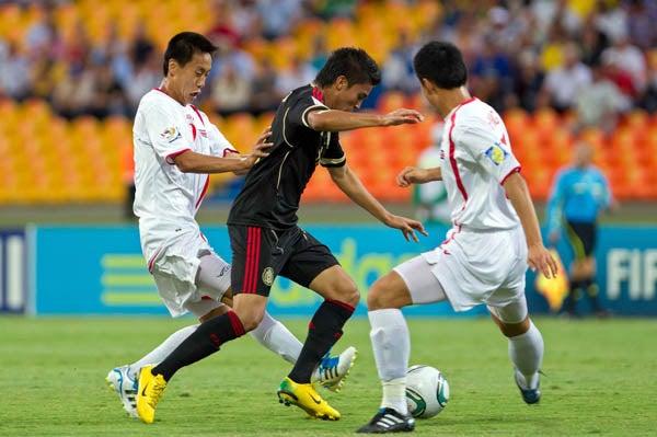 Ulises Davila pelea con los coreanos el esférico. FOTO: MEXSPORT