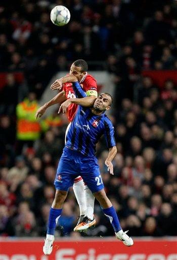 Rio Ferdinand pelea por el esférico con Marius Pena. FOTO: AP