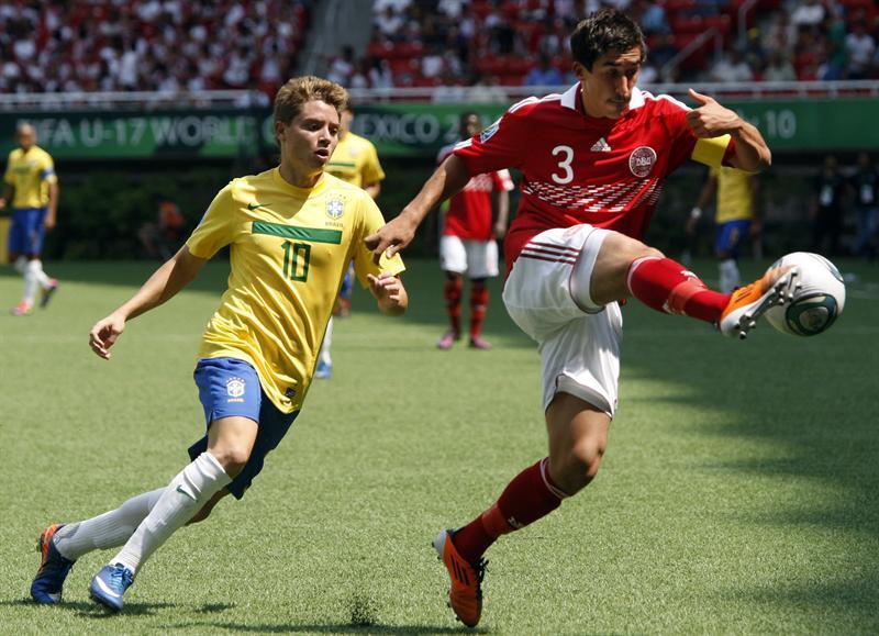 El delantero brasileño Adryan pelea el balón con Frederik Holst. FOTO: EFE