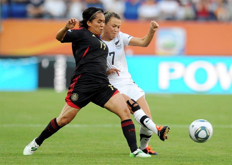Mónica Ocampo disputa el balón con Ali Riley. FOTO: EFE