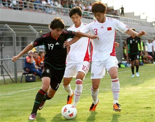 Edson Rivera controla el esférico ante la vista de los chinos, Pei Shuai y Wu Xinghan. FOTO: AP