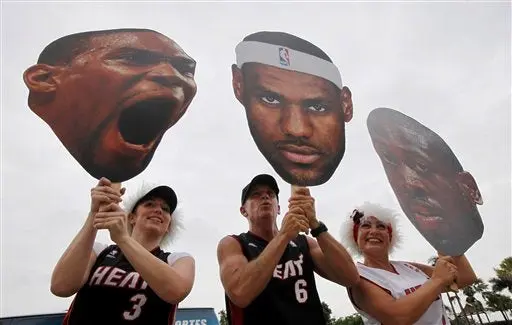 Aficionados con los rostros de Chris Bosh, LeBron James y Dwyane Wade l AP