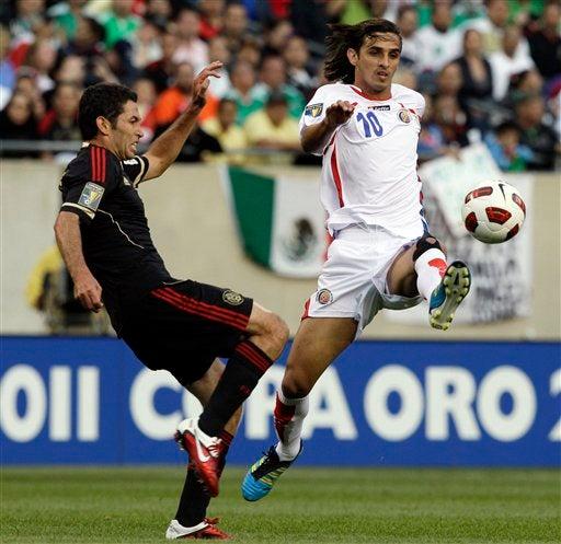 Castro en el medio campo disputa el balón con Bryan Ruiz. FOTO: AP