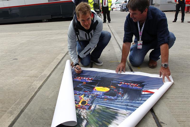 Vettel firma un póster a un fan en el paddock de del circuito de Silverston, en Northamptonshire. FOTO: EFE