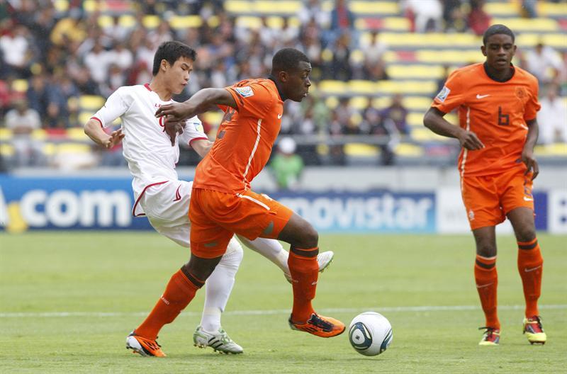 Jang Ok Chol disputa el esférico con  Danzell Gravenberch. FOTO: EFE