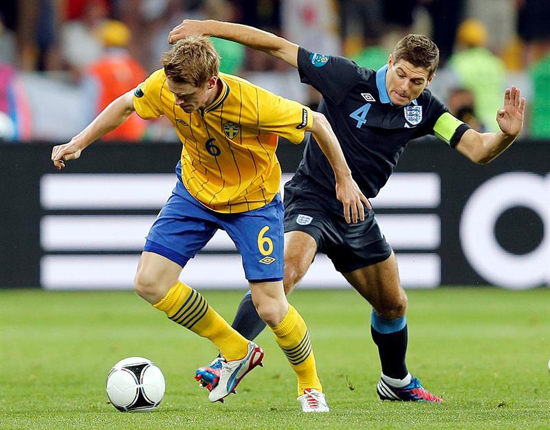 Rasmus Elm disputando el esférico con Steve Gerard l AP