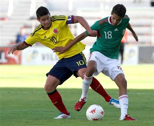 James Rodriguez Rubio de  Colombia se defiende de la marca del mexicano, Diego Reyes. FOTO: AP