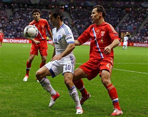 Giorgos Karagounis y Sergei Ignashevich peleando el balón l AP