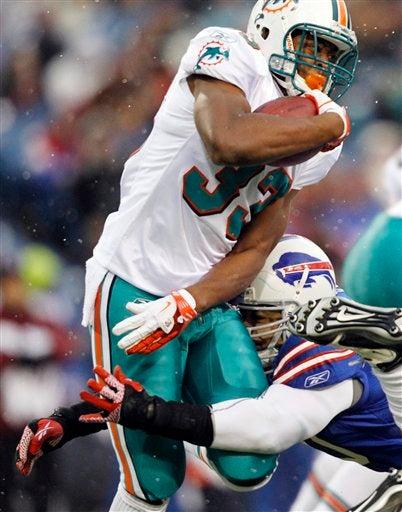Daniel Thomas  choca con Nick Barnett. FOTO: AP