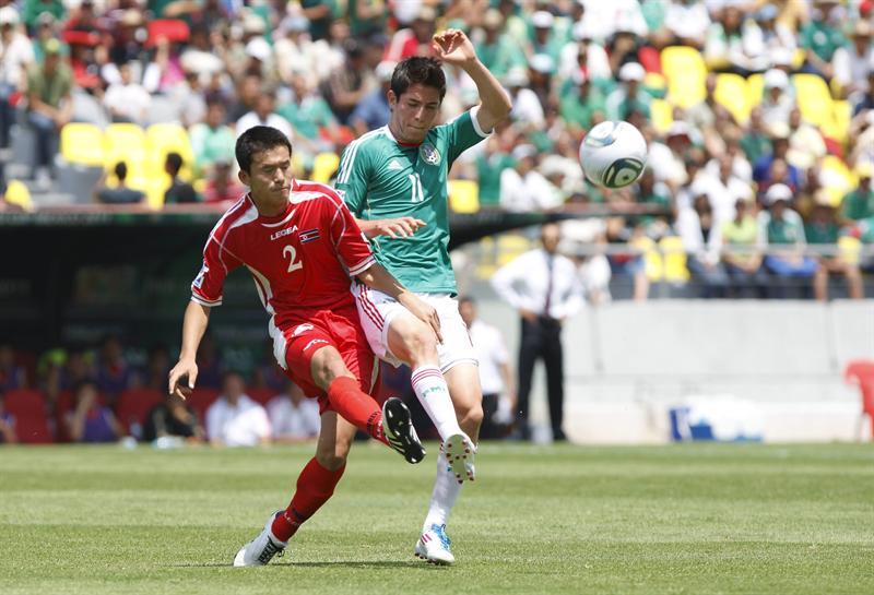 Marco Bueno y Jong Kwang Sok disputan el esférico. FOTO: EFE