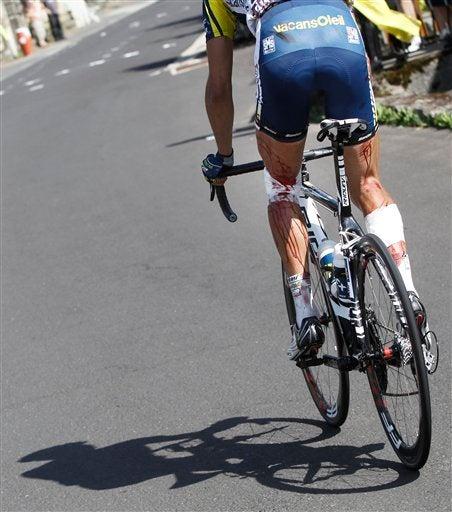 El ciclista tardó en recuperarse, tras caer en la valla de púas. FOTO: AP