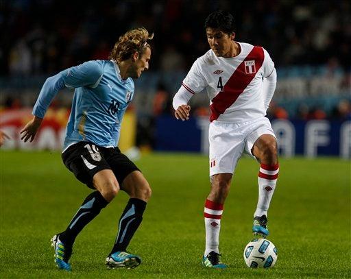Diego Forlán enfrenta a Walter Vilchez quien controla el esférico. FOTO: AP