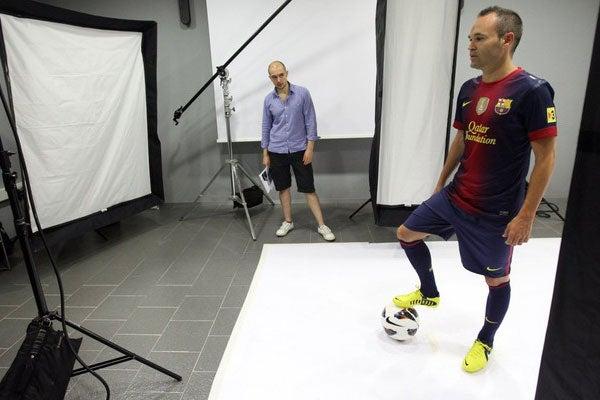 Andres Iniesta mira atento la cámara que lo capta deteniendo el balón.