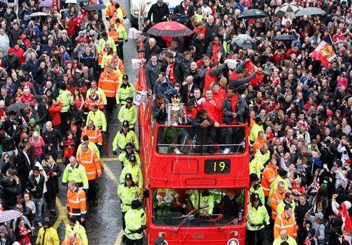 LOs jugadores festejan el título de la liga inglesa en las calles de Manchester. FOTO: AP