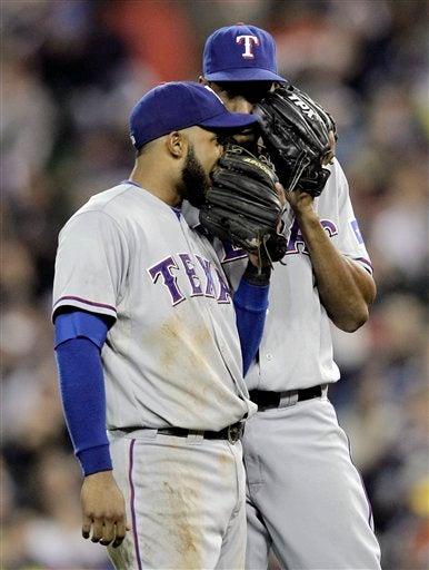 Elvis Andrus y Alexi Ogando dialogan en el diamante. FOTO: AP